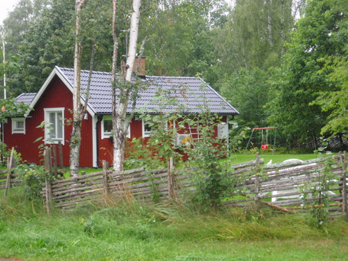 Classic barn red cottage house with Nordic fence.